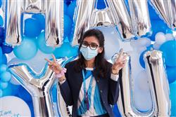 Employee posing in front of Thank You balloons