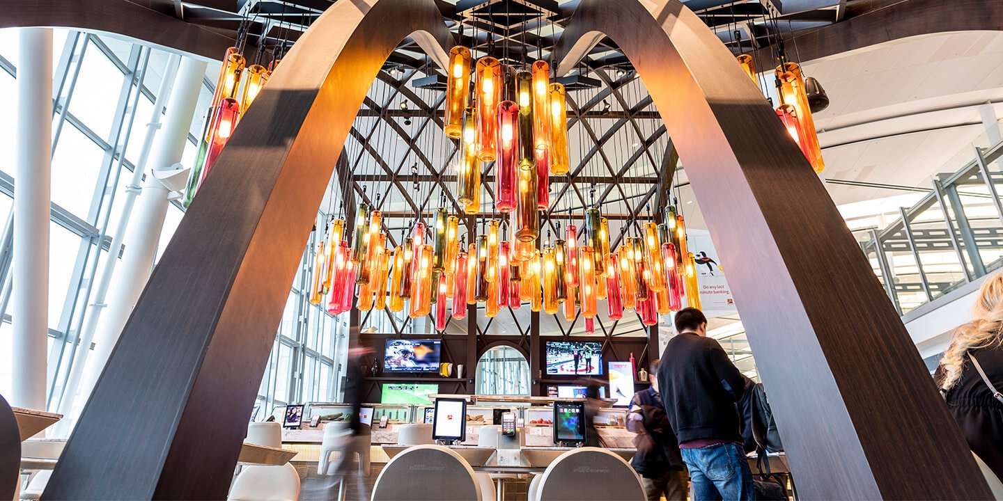 The curved beams and red, orange and brown tubular lights above Marathi restaurant