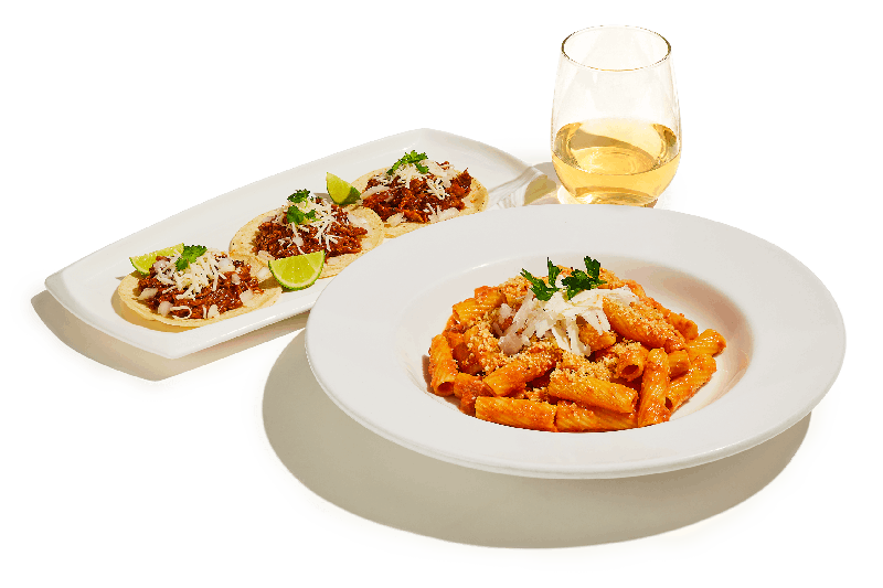 Rigatoni pasta, pork carnitas tacos and a glass of white wine.