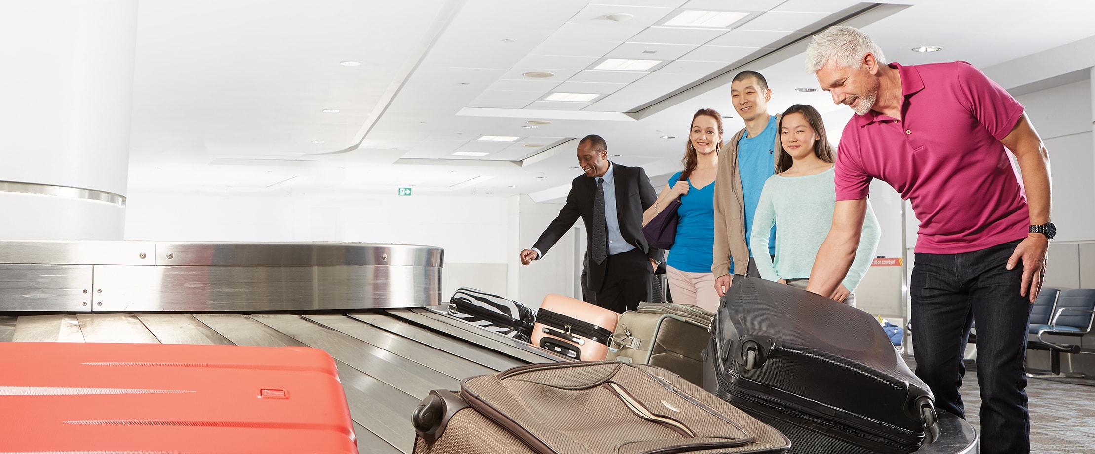 Travellers select their baggage off a Toronto Pearson carousel