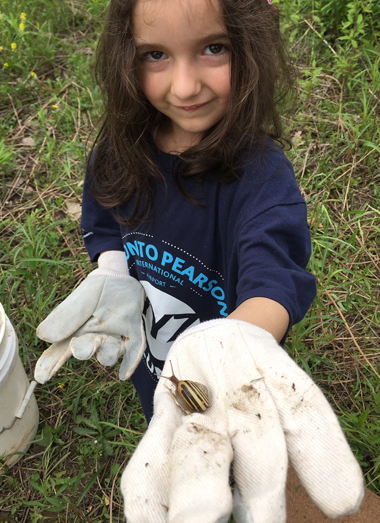 A little girl holds a snail at a Propeller Project event
