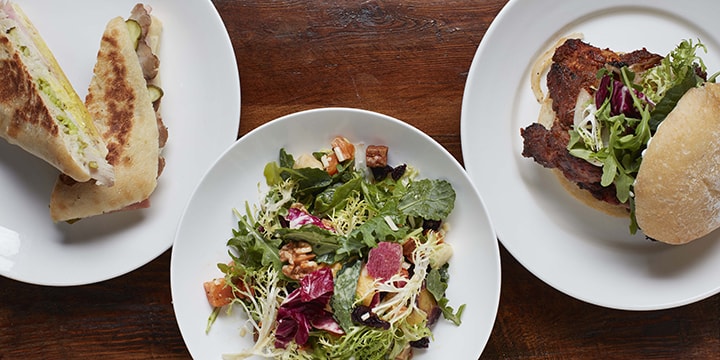 Flatlay of plates with sandwiches and salad