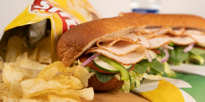 A Subway sandwich and a bag of chips