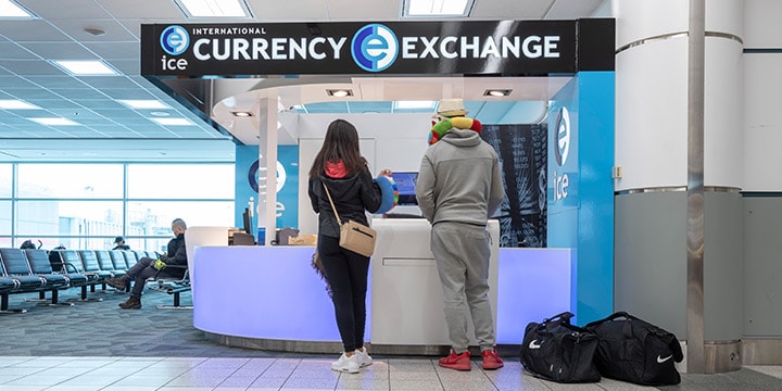 Des voyageurs au comptoir d’International Currency Exchange.