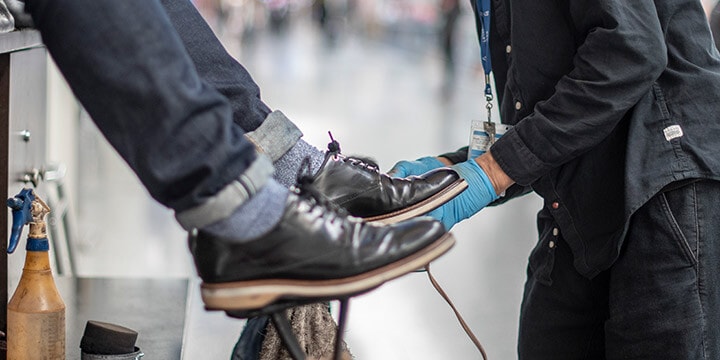 Un homme se fait cirer les chaussures à un kiosque Walter’s Shoe Care 
