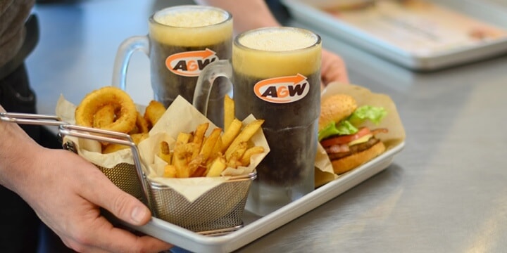 Plateau comprenant des frites, des rondelles d’oignon, une racinette et des hamburgers